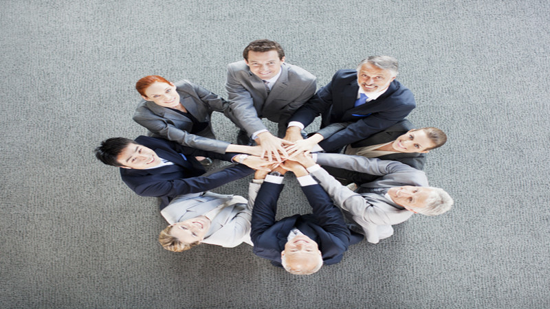 High angle view portrait of business people joining hands in circle